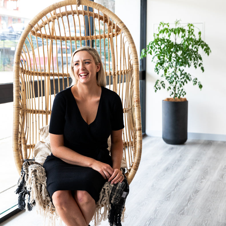 Jacinta sitting on cane hanging chair.